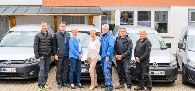 Das Team von Nicolaus Haustechnik vor den Firmenfahrzeugen in Gotha